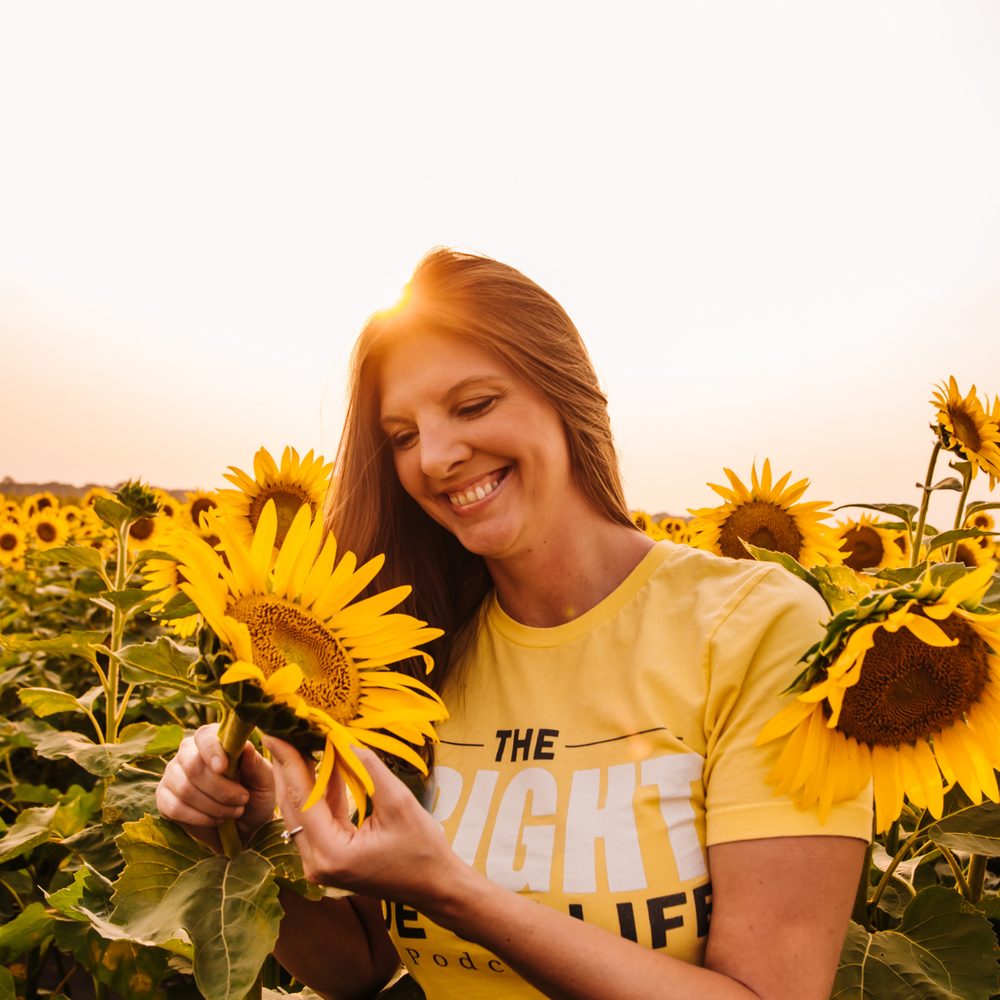 Melissa Bright smiling in a sunflower field
